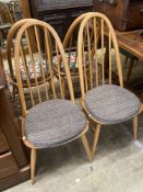A set of four Ercol light beech comb back Windsor dining chairs