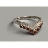 A modern 18ct gold, two row ruby and diamond set chevron ring, size M/N, gross 2.1 grams.