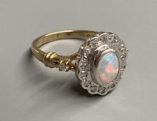 A modern 9ct gold, white opal and diamond chip set cluster ring, with diamond set shoulders, size O,