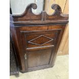 A George III oak hanging corner cabinet, width 72cm, depth 36cm, height 110cm