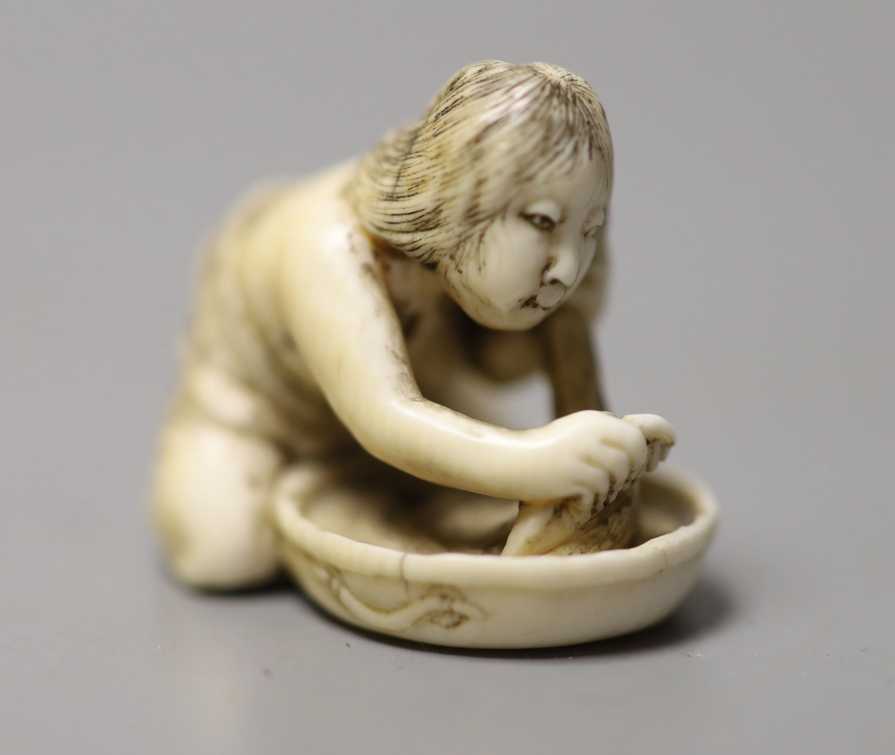 A 19th century Japanese ivory netsuke of a woman washing her hair, 3.5cm wide - Image 2 of 4