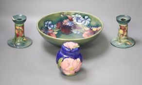 A pair of Moorcroft candlesticks, a jar and cover, and a bowl