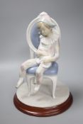 A Lladro figure of Harlequin Boy with cat sitting on a chair, no. 1229, 30cm high