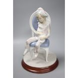 A Lladro figure of Harlequin Boy with cat sitting on a chair, no. 1229, 30cm high