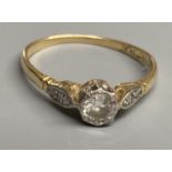 An 18ct & plat, single stone diamond ring, with diamond set shoulders, size P, gross 1.9 grams.