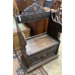 A small Flemish carved oak box seat settle, width 65cm, depth 40cm, height 104cm