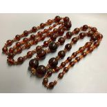 Two single strand reconstituted and natural amber necklaces, both approximately 80 cm, gross