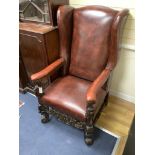 A Carolean style carved walnut and burgundy leather wing armchair, width 72cm, depth 86cm, height