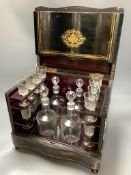 A French ebonised decanter case, c.1870, hinged lid opening to reveal four liqueur decanters and