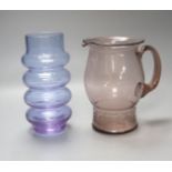 An Art glass pale amethyst jug with ribbed foot and a pale blue glass cylindrical ring-form vase,