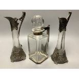 A pair of WMF style pewter-mounted glass jugs and an electroplate mounted spirit decanter, tallest