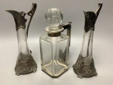 A pair of WMF style pewter-mounted glass jugs and an electroplate mounted spirit decanter, tallest