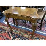 A Queen Anne revival walnut concertina folding card table, stamped Gill and Reigate, London retailed