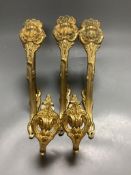 A pair of French ornate gilt curtain tiebacks and a set of three similar curtain brackets
