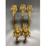 A pair of French ornate gilt curtain tiebacks and a set of three similar curtain brackets