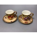A pair of Royal Worcester fruit painted coffee cups and saucers, signed Freeman, (one saucer