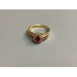 A modern 14 K yellow metal, ruby and diamond cluster ring, size M, gross 3.9 g.