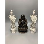 A Chinese dark brown glazed Buddha, and a pair of blanc de chine figures of Guanyin, tallest 30cm