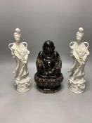 A Chinese dark brown glazed Buddha, and a pair of blanc de chine figures of Guanyin, tallest 30cm