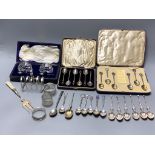 Three cased sets including silver teaspoons, a silver toast rack, three silver napkin rings and a
