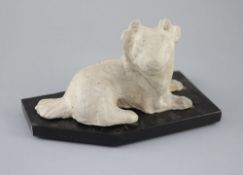 A Chinese grey pottery figure of a recumbent dog, Han dynasty or later23.5cm long, wood stand