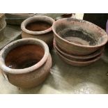 A pair of terracotta pots and three other terracotta pots, largest