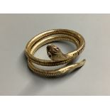 A 1960’s nine carat gold coiled serpent bracelet with ruby eyes, gross weight 30 .1 g.