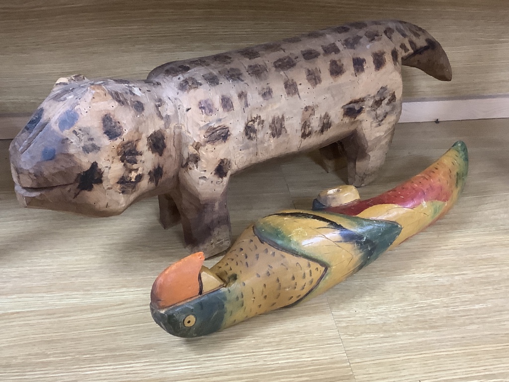 A decorative 20th century Brazilian carved wood dog and a painted carved wood parrot, longest