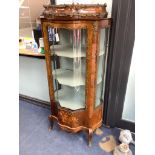 An early 20th century French gilt metal mounted rosewood vitrine, with central serpentine glazed