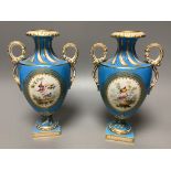 A pair of mid 19th century Coalport turquoise ground two handled vases, painted in Sévres style with