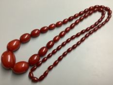 A single strand graduated oval simulated amber bead necklace, 100 cm, gross 91 grams.