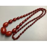 A single strand graduated oval simulated amber bead necklace, 100 cm, gross 91 grams.