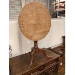 A George III faded oak circular tilt top tea table, 68cm diameter, height 72cm