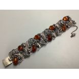 A 925 white metal and amber bracelet of foliate design, gross 56 grams.