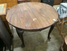 A 1920's circular mahogany extending dining table with three leaves and handle, length approx.