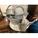 Two galvanised tubs, larger width 80cm, together with four watering cans