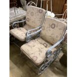 A pair of painted wrought iron garden rocking armchairs with cushion seats, width 57cm, depth
