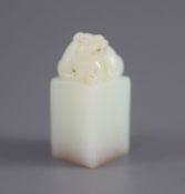 A Chinese inscribed white jade seal, 20th century,surmounted by the figure of a lion-dog, the