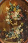 19th century Italian SchoolStill life of flowers in an urn upon a pedestal, a wall and trees