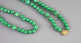 A Chinese green jadeite bead necklace,gilt metal clasp strung with 7mm beads interspersed by 10mm