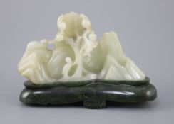 A Chinese pale celadon jade boulder carving, Qing dynasty,carved in high relief and openwork with a