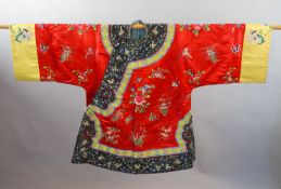A Chinese red silk robe, early 20th century,embroidered with spot motifs of butterflies, flowers