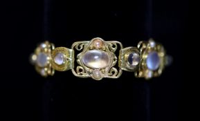 An early 20th century Arts & Crafts gold, cabochon moonstone and split pearl set bracelet,with