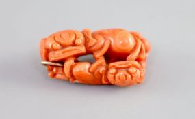 A Chinese coral ‘lion-dog’ pendant, 19 century,carved in high relief and openwork with two lion-