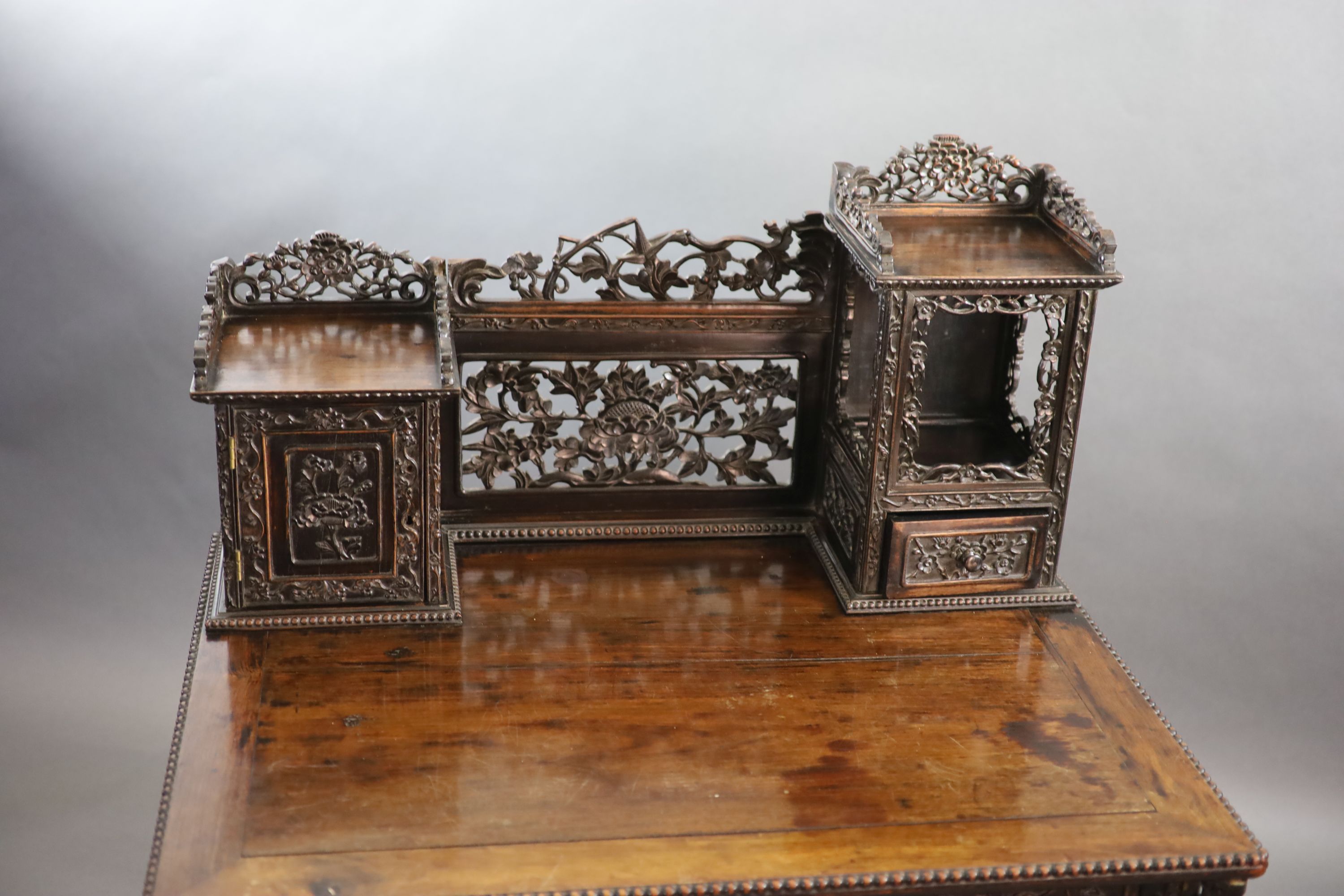 A late 19th century Chinese hongmu desk,carved and pierced throughout with flowers, the raised - Image 3 of 4