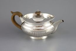 A George III demi-fluted silver squat circular teapot, by Robert & Samuel Hennell,with engraved