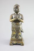 A Chinese bronze standing figure of Shancai Tongzi,on a rectangular base with four shaped feet,34cm