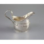 An Edwardian Arts & Crafts planished silver cream jug by John Gatecliff,with band of engraved '