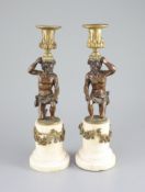 A pair of 19th century bronze and ormolu figurative candlesticks,with kneeling figures raising
