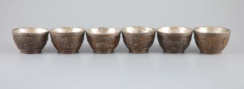 A set of six Chinese coconut cups, 18th/19th century,each carved in relief with figures amid